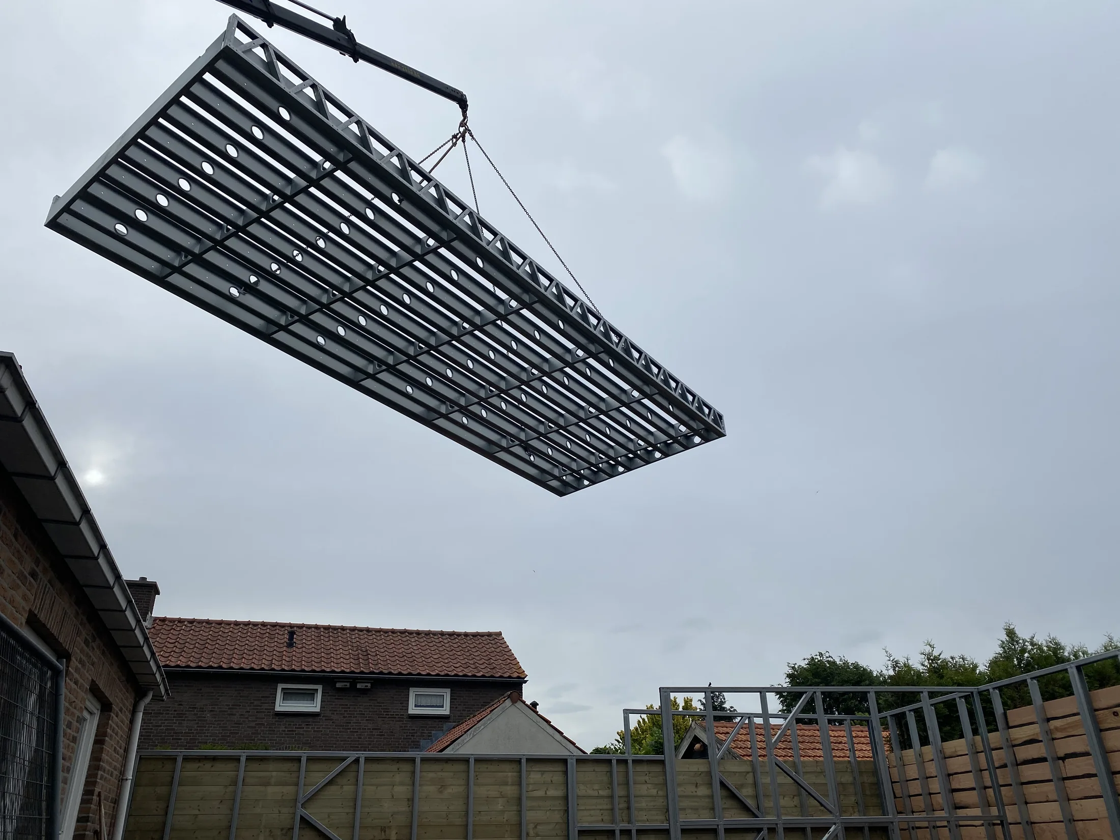 Staalframe-element tijdens plaatsing met een kraan