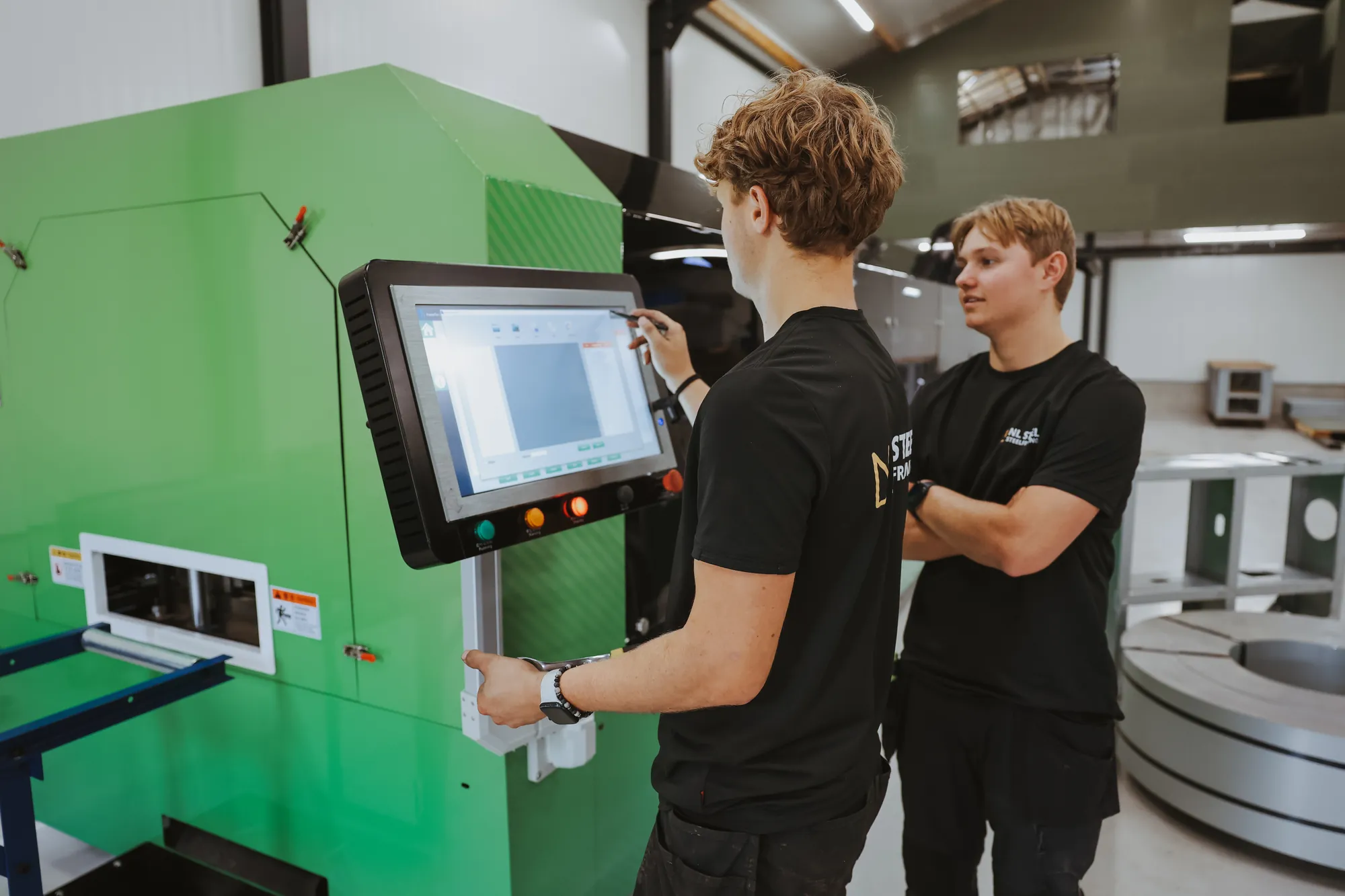 Het team van NL Steel bij het besturingspaneel van de productiemachine